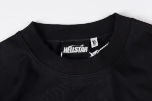 Close-up of the neckline of a black Hellstar Studios T-shirt featuring the brand logo tag, emphasizing its pure cotton material and quality design.