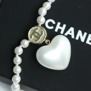 Chanel 21FW Love Pearl Earrings Necklace Set featuring a heart-shaped white mother of pearl pendant and gold logo charm on a pearl strand.