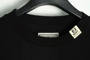3MMY black crew neck cotton T-shirt on black wooden hanger close-up neckline view
