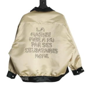 No brand, model number, or product type provided for this beige satin jacket with black collar and cuffs and embroidered French text on the back