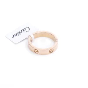 Cartier LOVE Series Ring in rose gold with signature screw motif and brand tag.