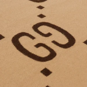 Gucci GG logo detail on jacquard wool scarf, showcasing luxury fashion design and branding.