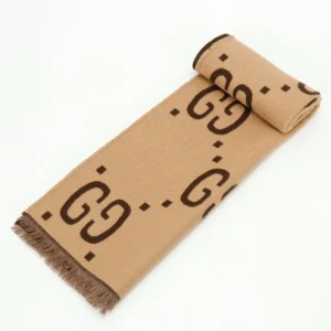 Gucci GG Large Logo Jacquard Wool Scarf in beige with brown GG pattern, showcasing luxury design and soft texture, ideal for stylish winter accessories.