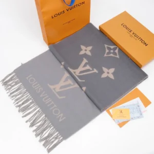 Louis Vuitton gradient cashmere fringe scarf displayed with packaging, showcasing luxury design and brand logo.