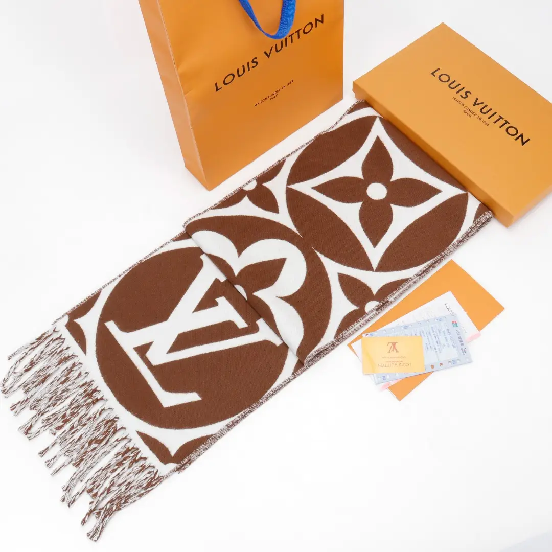 Louis Vuitton Mahjong Double Sided Wool Cashmere Tassel Scarf displayed with branded packaging and accessories, featuring iconic LV logo and floral pattern.