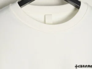 Chrome Hearts hoodie with a round neck and leather cross sticker detail, hanging on a black hanger against a neutral background.