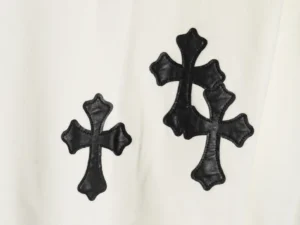 Black leather cross patterns on a white Chrome Hearts hoodie, showcasing intricate design details and premium craftsmanship.
