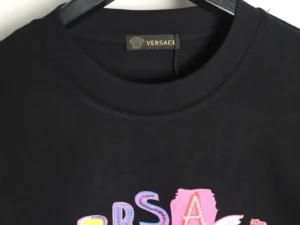 Versace sweatshirt featuring colorful painted sequins and Medusa design, showcasing brand logo and craftsmanship details.