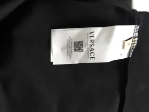 Versace clothing tag featuring the brand name and QR code, associated with the Versace Painted Sequins Medusa People sweatshirt.