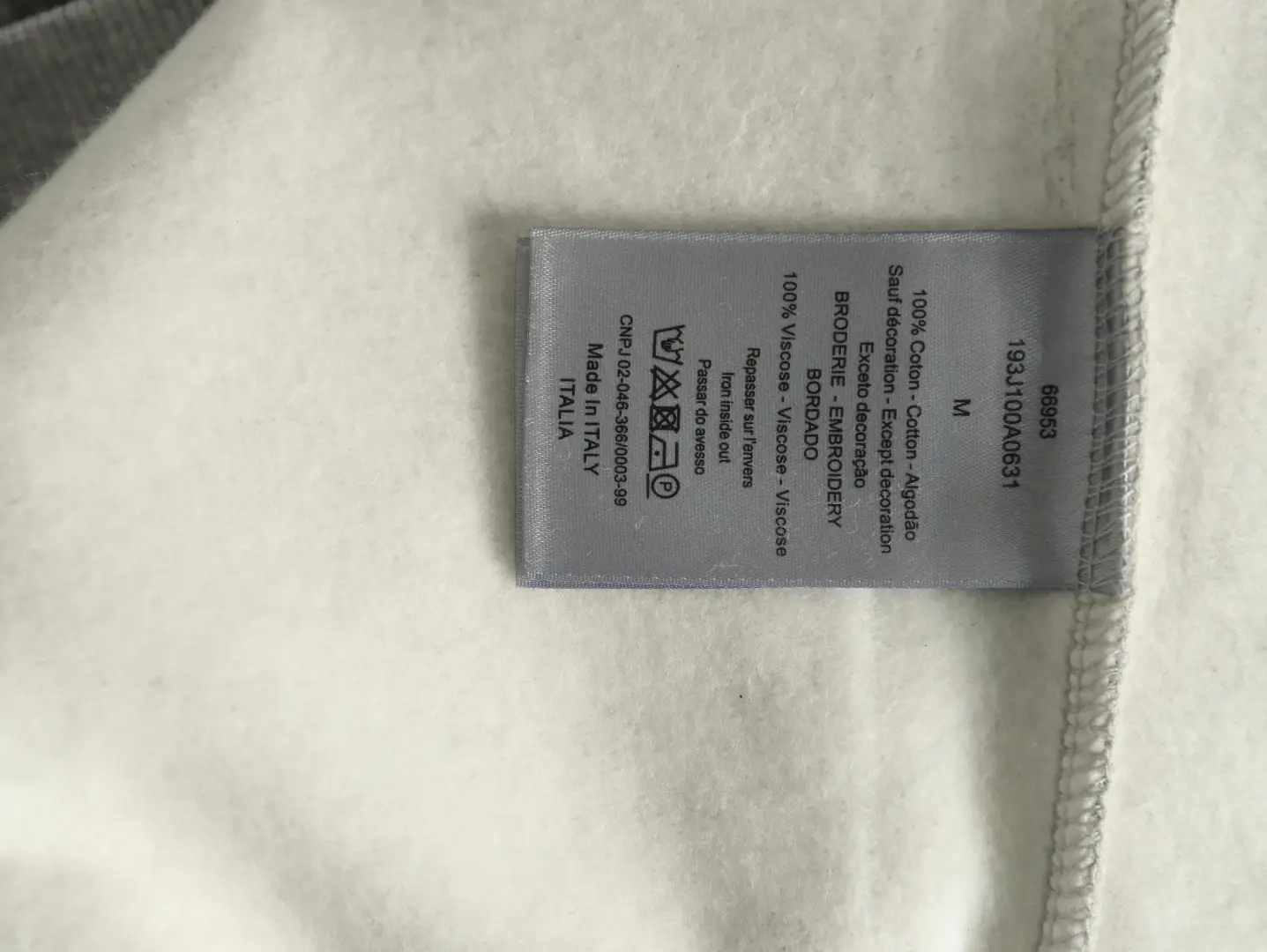 No brand or product details visible on clothing care label for SEO alt text generation.