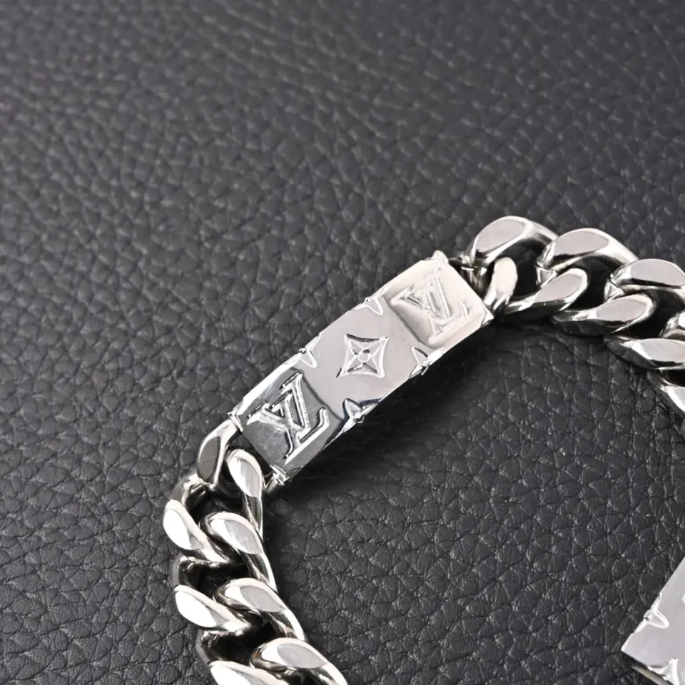 Louis Vuitton bracelet silver-tone metal engraved logo chain accessory on black surface