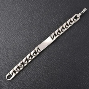 Louis Vuitton Monogram chain bracelet (M00855) featuring a silver Cuban chain design, showcasing engraved Monogram patterns, on a textured black background.