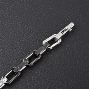 Louis Vuitton Bamboo Series Black Silver Bracelet showcasing intricate craftsmanship, featuring LV initials and stylish link design on a textured black background.