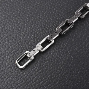 Louis Vuitton Bamboo Series Black Silver Bracelet on textured black background, showcasing intricate craftsmanship and distinctive links with LV initials.