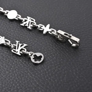 Silver Louis Vuitton Monogram Craggy chrysanthemum necklace with logo charms, showcasing glossy brass elements and a clasp, emphasizing luxury accessory design.