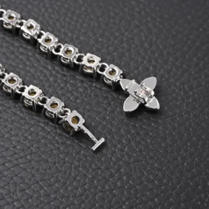 Louis Vuitton LV Crystals Diamond Letters bracelet featuring circular cut zircon stones, polished metal chain links, and floral hook closure, set against a textured black background.