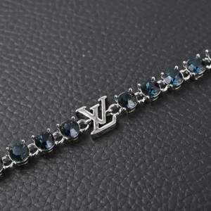 Louis Vuitton CRYSTALS Diamond Letters bracelet featuring circular cut zircon stones, polished metal chain links, and LV logo decoration, set against a textured black background.