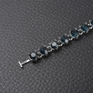 Louis Vuitton LV Crystals Diamond Letters bracelet featuring circular cut zircon stones and polished metal chain links, showcased on textured black background.