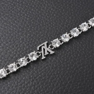 Tiffany & Co. tennis bracelet silver with round clear crystal stones and logo charm on black textured background