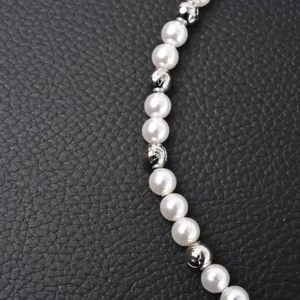 Louis Vuitton Monogram Pearls necklace featuring polished pearl beads and metallic accents, displayed on a textured black background.