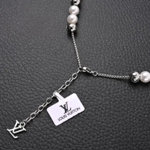 Louis Vuitton Monogram Pearls necklace featuring pearl beads and adjustable chain with LV logo tag, showcasing luxury design elements.