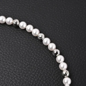 Louis Vuitton Monogram Pearls necklace featuring alternating pearl and polished beads on a textured black background.