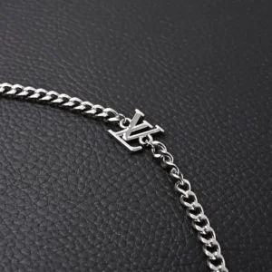 Louis Vuitton bracelet silver chain LV logo polished metal accessory on black textured background
