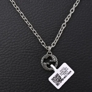 Gucci GUC 3D Double G Pure Silver Pendant Necklace on a textured black background, featuring a silver chain and a tag with a QR code.