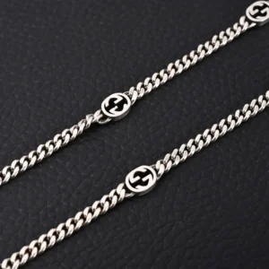 Gucci chain necklace silver metal interlocking GG logo design accessory on black background