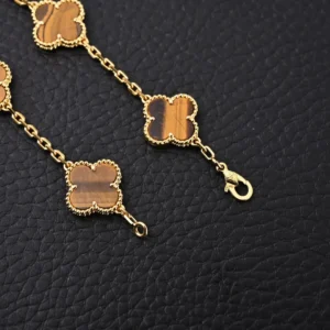 Van Cleef Arpels-inspired yellow gem Fritillaria four leaf clover bracelet with gold electroplating and intricate details on a textured black background.