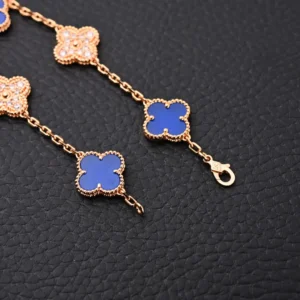 Van Cleef Arpels Blue Fritillaria bracelet with four leaf clover and five flower design, featuring electroplated 18K gold and intricate details on a textured black background.