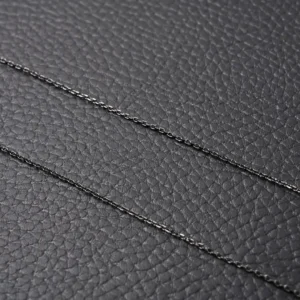 Van Cleef Arpels Flower Necklace chains displayed on a textured black background, emphasizing luxury jewelry details.