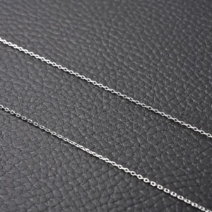 Silver chain necklace displayed on a textured black background, showcasing the sleek design of the Van Cleef Arpels Classic Clover Necklace.