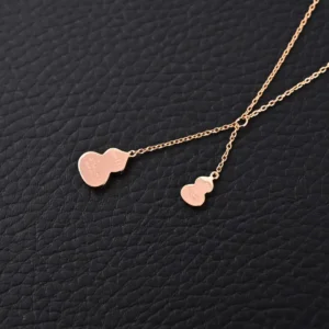 Qeelin Kirin Tassel Natural Beimu Gourd Necklace featuring dual gourd pendants on a delicate chain, showcasing pure silver electroplating and 18k gold finish, against a textured black background.