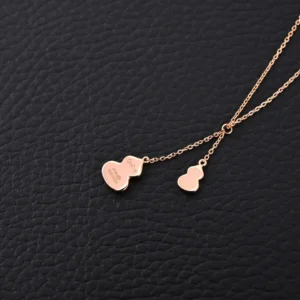 Qeelin Kirin tassel necklace featuring red agate gourd design, crafted with pure silver electroplating and 18k gold, displayed on textured black background.