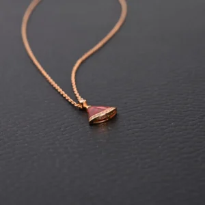 BVLGARI Diva fan-shaped necklace featuring red agate and white mother of pearl, adorned with diamonds, displayed on a dark background.