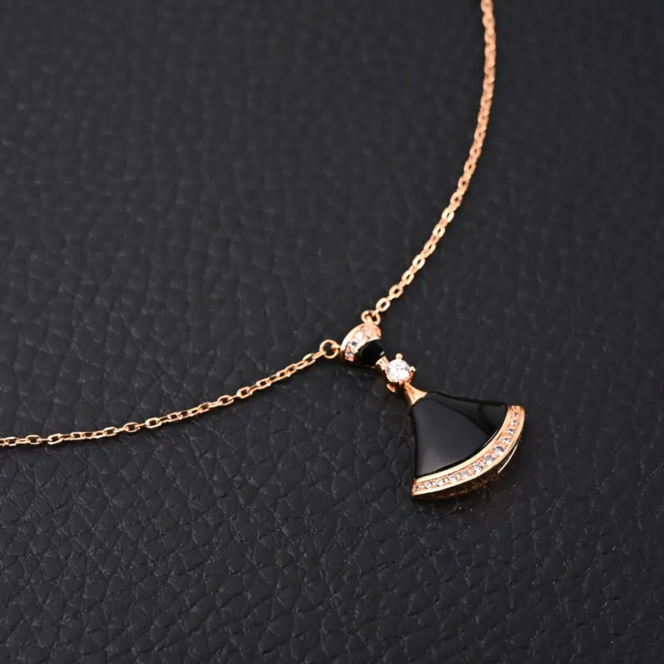 Unbranded necklace black pendant rose gold chain with crystal accents on black textured background