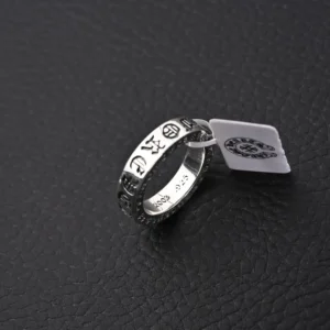 Chrome Hearts CH Forever Sanskrit Cross Ring displayed on textured black surface, featuring engraved symbols and a price tag.