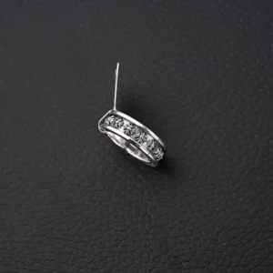 Chrome Hearts CH Cross Ring in vintage silver featuring intricate design and decorative embellishments, showcased on a textured black background.