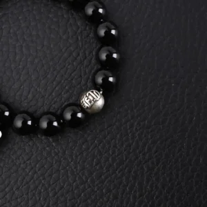 Chrome Hearts Silver Bead Obsidian Bracelet featuring black obsidian beads and a silver bead with logo detail, set against a textured black background.