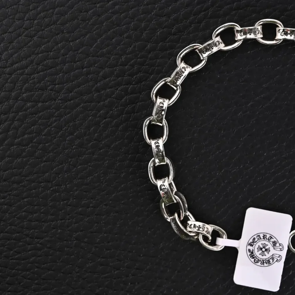 Chrome Hearts silver chain bracelet engraved links metal accessory with branded tag on black textured background