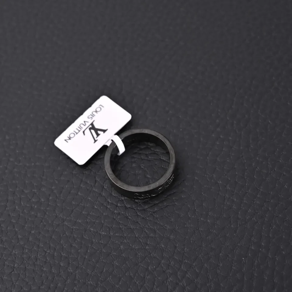 Louis Vuitton ring black metal band accessory with LV logo tag on textured black surface