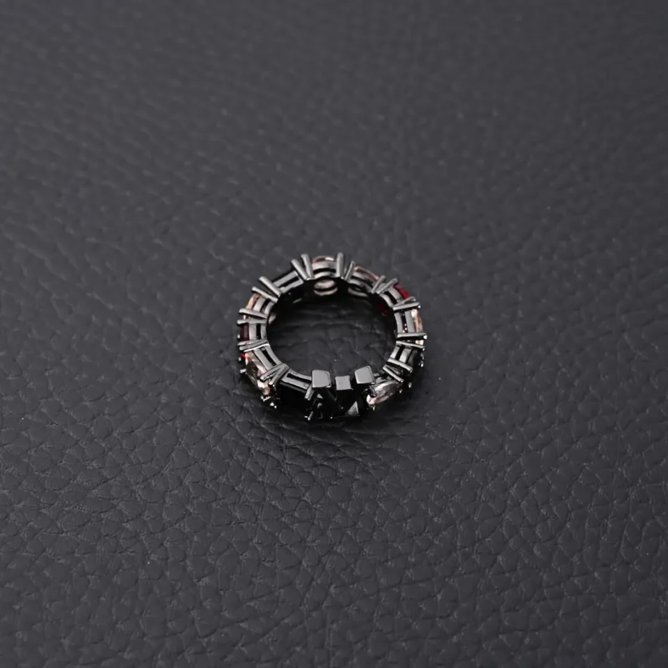 Unknown brand geometric design ring black metal with silver and dark accents on textured black surface