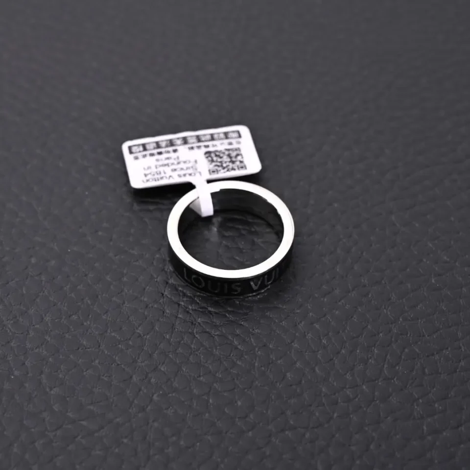 Louis Vuitton ring black silver-tone metal logo band accessory with price tag on black textured surface