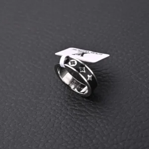 Louis Vuitton LV X Nigo co-branded enamel ring displayed on textured black background, featuring star and logo designs, with attached tag for authenticity.