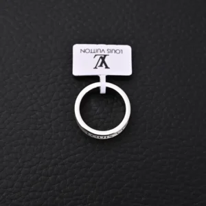 Louis Vuitton LV x Nigo co-branded enamel ring displayed on a textured black surface, featuring a visible logo tag.