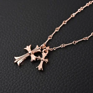 Chrome Hearts double cross pendant necklace on a textured black background, showcasing intricate design and rose gold finish.