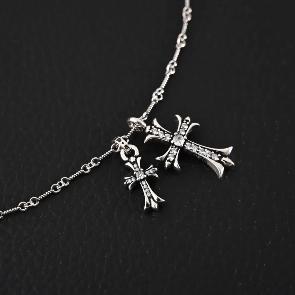 Chrome Hearts cross pendant necklace silver metal with diamond-like crystal accents on black background