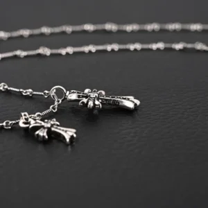 Chrome Hearts Double Cross Pendant Necklace featuring silver cross pendants on a delicate chain against a dark background.