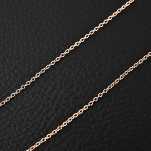 Generic rose gold chain necklace delicate links lightweight accessory on black textured background